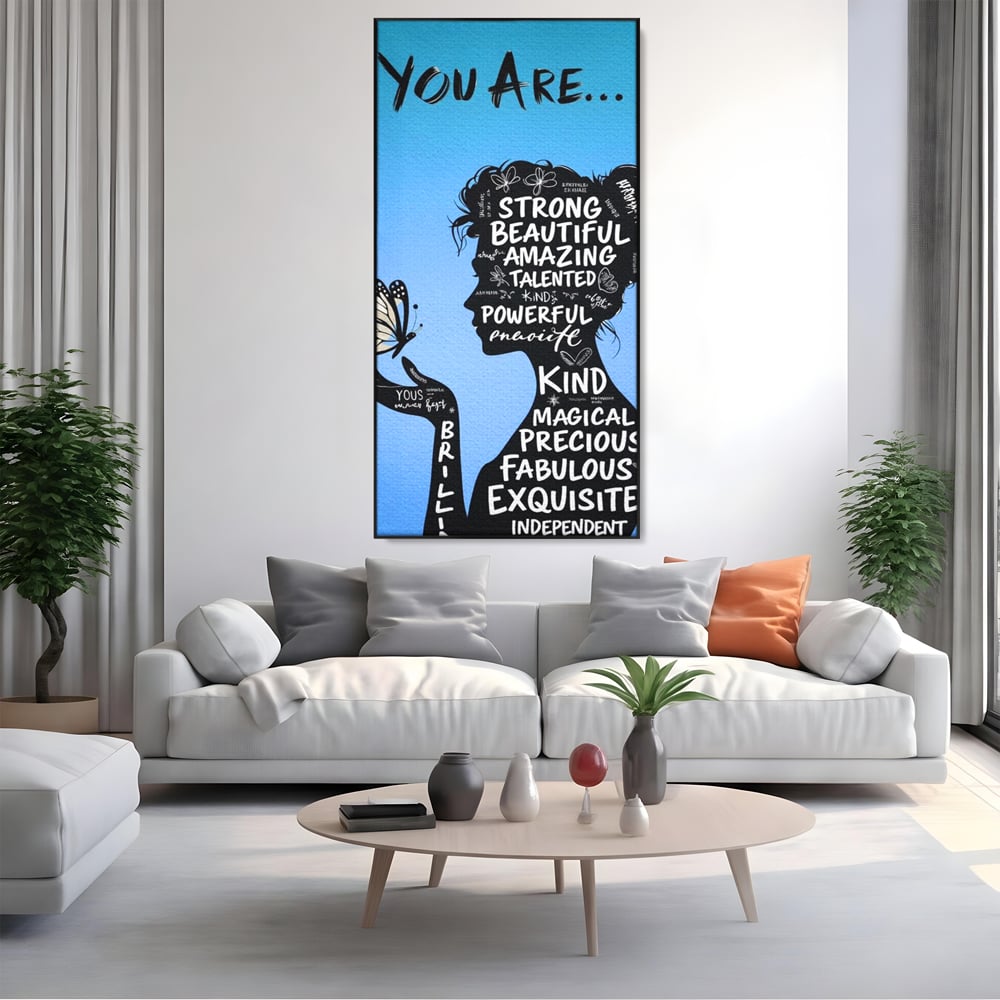 Tablou canvas cu tablou motivational cu portret de femeie si cuvinte, in rama de aluminiu negru, pe perete intr-un living